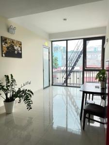 a living room with a table and a balcony at Pharma Hotel in Diện Biên Phủ