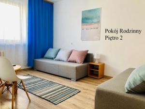 a living room with a couch and blue curtains at Krysia - tuż przy plaży in Mielno