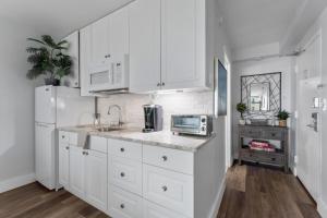 a kitchen with white cabinets and a sink and a microwave at oceanside inn in Daytona Beach