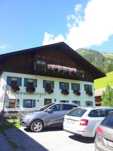 a building with cars parked in front of it at Ferienwohnungen Wolf in Holzgau