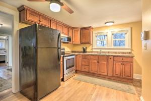 a kitchen with wooden cabinets and a stainless steel refrigerator at Cozy Campbell Hall Getaway with Porch! in Campbell Hall