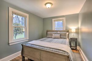 ein Schlafzimmer mit einem Bett und zwei Fenstern in der Unterkunft Cozy Campbell Hall Getaway with Porch! in Campbell Hall