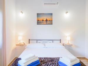 ein weißes Schlafzimmer mit einem Bett mit zwei Lampen in der Unterkunft Cubo's Villa Marifran in Cártama + 52 Fotos