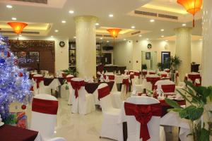a banquet hall with white chairs and a christmas tree at Thien Hong - Arc En Ciel Hotel in Ho Chi Minh City