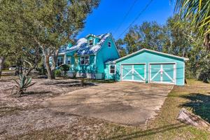 a blue house with a white garage at Serene Pensacola Vacation Rental with Gas Grill in Pensacola