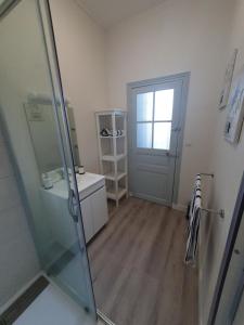 łazienka z prysznicem i szklanymi drzwiami w obiekcie Appartement au cœur du village d'Aufferville w mieście Aufferville