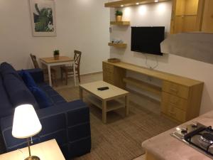 a living room with a blue couch and a tv at Royal Luxury Apartments & Studios in Amman +24 photos