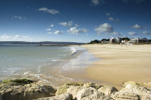 a view of a beach with rocks and the ocean at The Canford in Poole