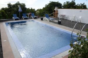 a swimming pool with blue chairs and a table at Las Casitas - Bung. A in Tijarafe
