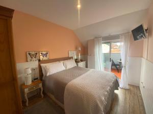 a bedroom with a large bed and a balcony at Apartamento Mar do Grove in O Grove