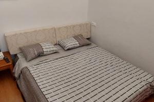 a bed with two pillows on it in a bedroom at Cosy and roomy 78m2(Μονοκατοικία) in Piraeus