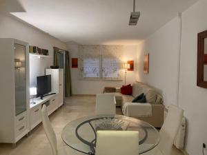 een woonkamer met een tafel en een bank bij Estepona Port Apartment in Estepona