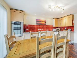 a large kitchen with a wooden table and chairs at Galena in Glenridding
