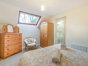 a bedroom with a bed and a dresser and a window at Galena in Glenridding