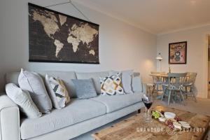 a living room with a couch with a map on the wall at 2 bed, 2 bath apartment, balcony with sea and island views, parking - Island Views in Poole