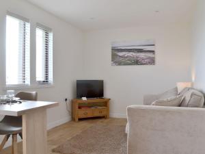 a living room with a couch and a table and a tv at Rockworks Chalets No,5 - Uk7044 in Saint Marys