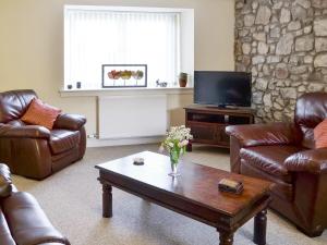 a living room with leather furniture and a coffee table at The Granary - Uk5676 in Boʼness