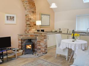 een woonkamer met een open haard en een tafel met stoelen bij The Old Forge in Saxilby