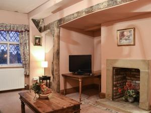 a living room with a tv and a fireplace at Tudor House in Easingwold
