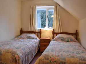 two twin beds in a bedroom with a window at Tudor House in Easingwold
