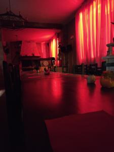 Habitación oscura con iluminación roja y mesa. en Hotel Transilvania, en Pian del Voglio