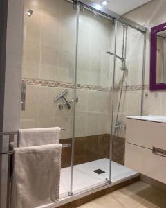 een douche met een glazen deur in de badkamer bij Estepona Port Apartment in Estepona