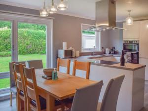 cocina y comedor con mesa de madera y sillas en Dykenamar, en Kilchattan