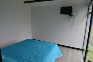 um quarto com uma cama e uma televisão na parede em CABAÑAS SALEKA Paipa 