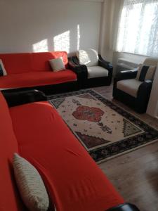 sala de estar con sofá rojo y sillas en Ozkok apartman, en Mustafakemalpaşa