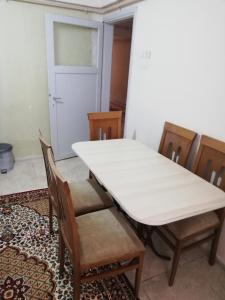 una mesa blanca y sillas en una habitación con puerta en Ozkok apartman, en Mustafakemalpaşa