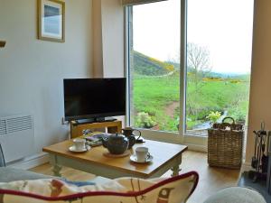 a living room with a coffee table and a large window at Bridge Cottage in New Channelkirk