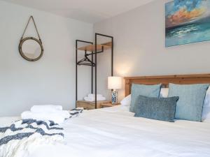 um quarto com uma cama branca e almofadas azuis em Y Bwthyn em Haverfordwest