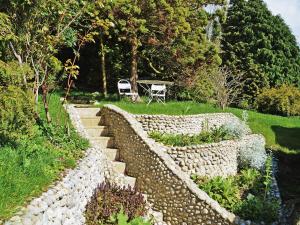 a stone retaining wall with stairs and chairs in a garden at Forge Cottage in Stiffkey