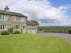 an old stone house with a large yard at Far View Cottage in Haworth