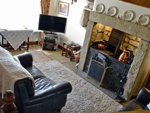 a living room with a couch and a fireplace at Far View Cottage in Haworth