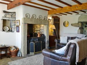 a living room with a fireplace and a couch at Far View Cottage in Haworth