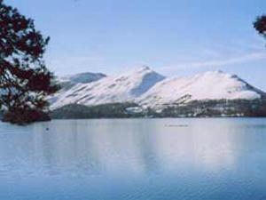 uma vista para um lago com montanhas cobertas de neve em Rambling Rose- Lwg em Ireby