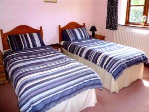 twee bedden naast elkaar in een kamer bij Stildon Manor Cottage in Pensax