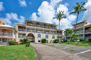 a building with palm trees in front of it at Diamant Beach in Le Diamant