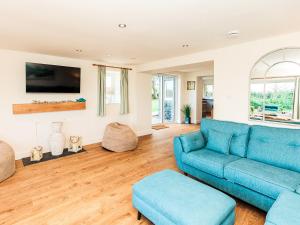 a living room with a blue couch and wooden floors at Robins Nest in Kirkcudbright
