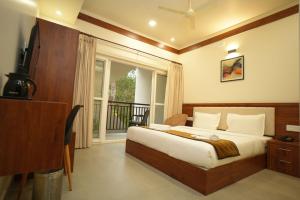 a bedroom with a large bed and a balcony at Royalton Residency in Mundakāyam