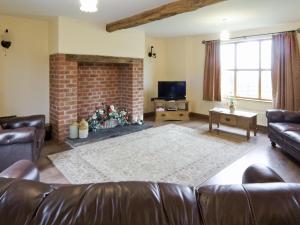 a living room with a couch and a fireplace at Cwm Corn Barn - Hw7662 in Mochdre