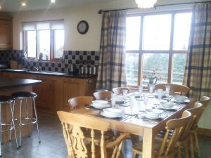 a kitchen with a wooden table with chairs and a dining room at Cwm Corn Barn - Hw7662 in Mochdre
