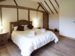 a bedroom with a large bed with towels on it at Cwm Corn Barn - Hw7662 in Mochdre
