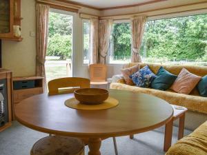 una sala de estar con una mesa con un tazón. en Spinney Retreat en East Wellow