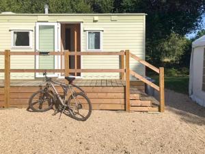 una bicicleta estacionada frente a una casa pequeña en Spinney Retreat en East Wellow