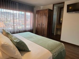 una camera da letto con un grande letto con una grande finestra di Casa Esmeralda by Katari a Cuzco