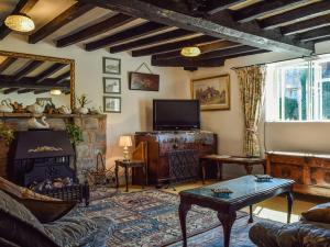 a living room with a couch and a fireplace at Tudor Cottage in Bidford