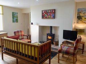 a living room with a fireplace and a tv at Brierdene End Cottage in Hartley