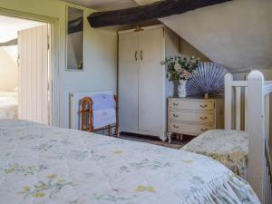 a bedroom with a bed and a dresser at Tudor Cottage in Bidford